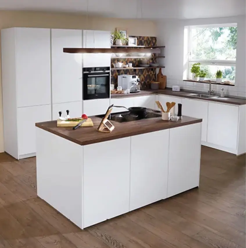 Helle Einbauküche mit Kochinsel, weißen Fronten und Arbeitsplatte in Holzoptik. Offene Küche mit Stauraum, Backofen, Spüle und dekorativen Elementen für modernes und funktionales Küchendesign.